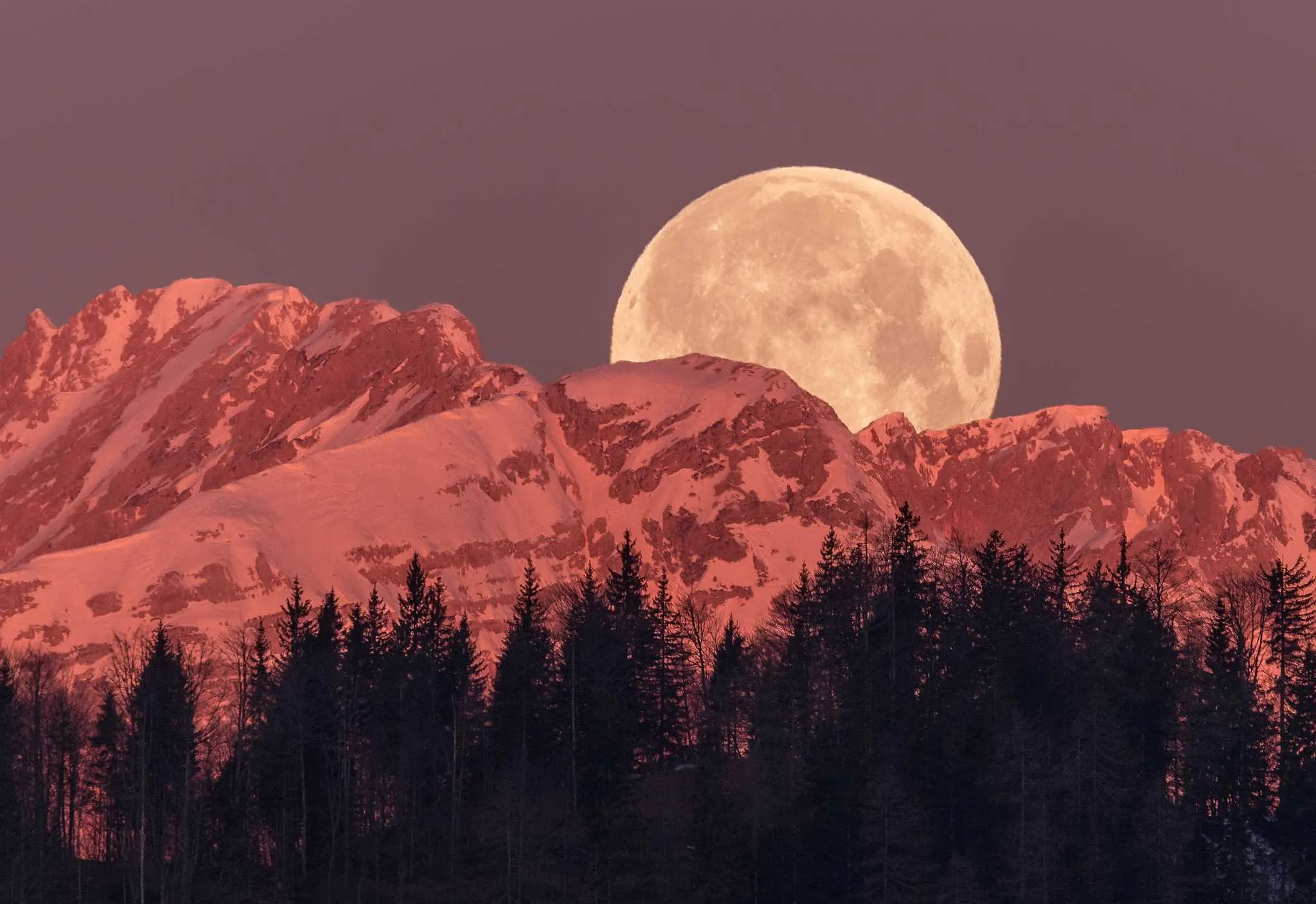 Imagem da Lua Cheia surgindo entre montanhas rochosas, com tons escuros e presença firme, representando foco e responsabilidade, por CenárioMT / Canva