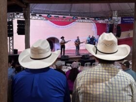 Palco do Encontro Nacional de Violeiros de Poxoréu durante apresentação da viola caipira, com público reunido no Parque de Exposições.