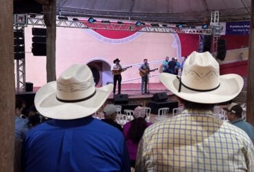Palco do Encontro Nacional de Violeiros de Poxoréu durante apresentação da viola caipira, com público reunido no Parque de Exposições.