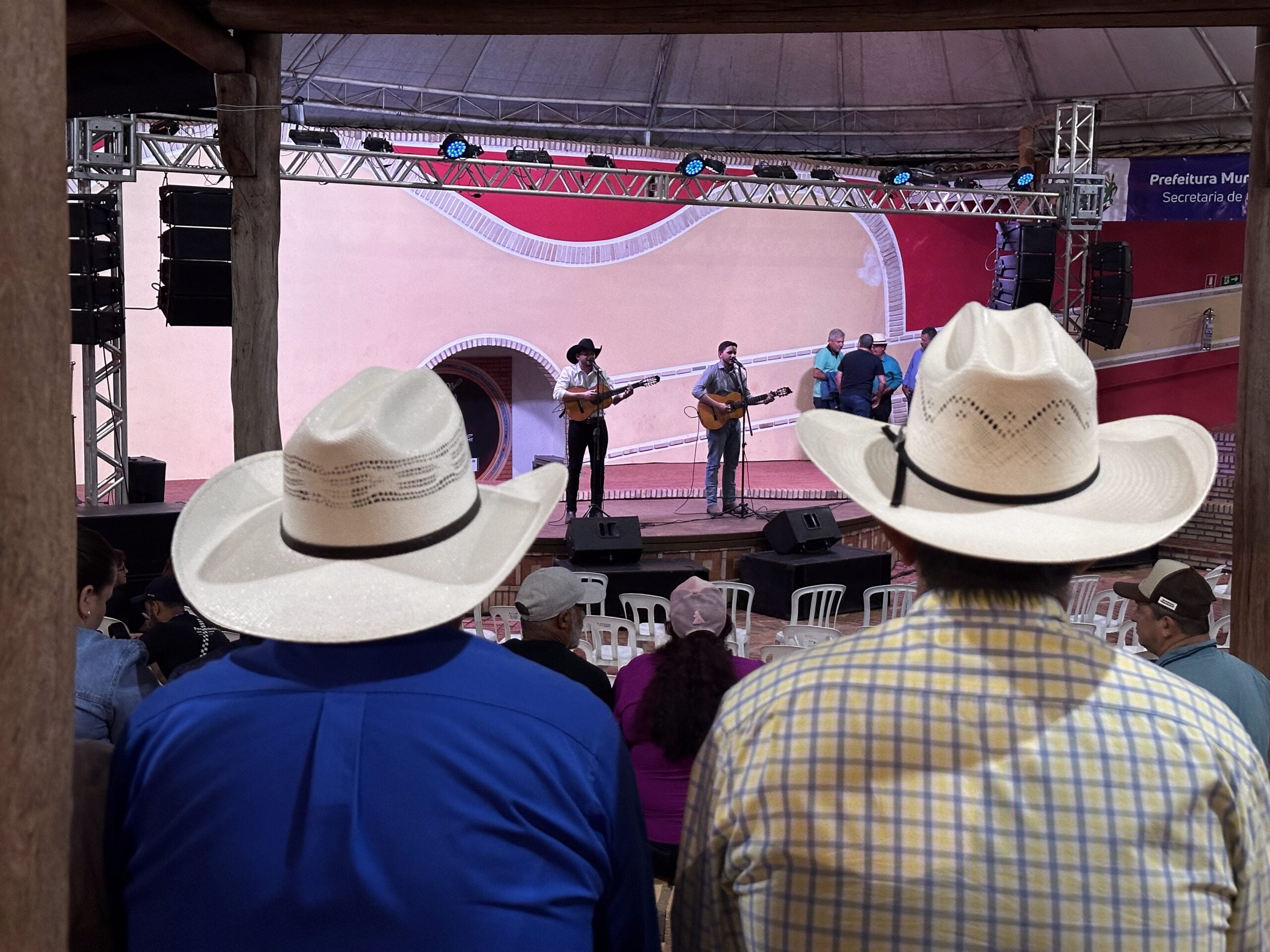 Palco do Encontro Nacional de Violeiros de Poxoréu durante apresentação da viola caipira, com público reunido no Parque de Exposições.