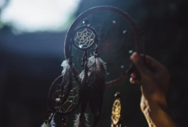 ustração editorial do Arcanjo Haniel irradiando luz suave sobre quatro signos do zodíaco, simbolizando favorecimento amoroso.