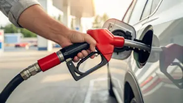 Foto de pessoa segurando bico de abastecimento para abastecer o carro