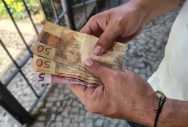 Foto de homem segurando dinheiro