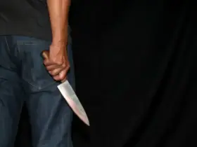Foto de homem segurando faca com fundo preto