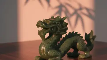 Detalhe de escultura de jade verde em ambiente sereno representando a sabedoria do horóscopo chinês.