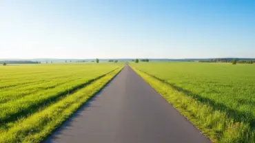 Estrada aberta em campo verde sob a luz do sol da manhã simbolizando novos começos.