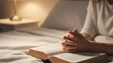 Bíblia aberta e mãos em oração simbolizando a paz de uma noite católica de sábado.