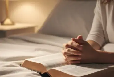 Bíblia aberta e mãos em oração simbolizando a paz de uma noite católica de sábado.