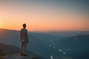 Pessoa observando o horizonte ao entardecer em momento de reflexão e paz interior.