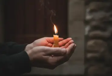 Uma Vela acesa em ambiente calmo simbolizando o início de um período de reflexão e fé.