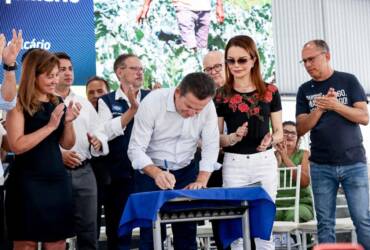 mauro mendes assinando documento em evento