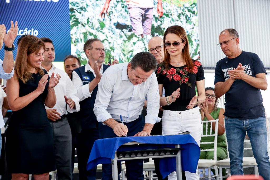 mauro mendes assinando documento em evento