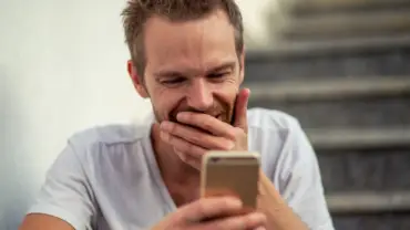 Homem no celular sorridente