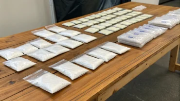 Pacotes de cocaína enfileirados em mesa de delegacia