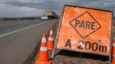 Obras da Rota do oeste, placa ao lado da rodovia indicando para o motorista parar a frente