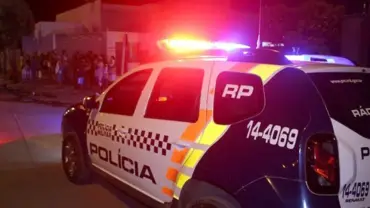 Viatura da polícia militar trafegando em via pública em direção à grupo de pessoas