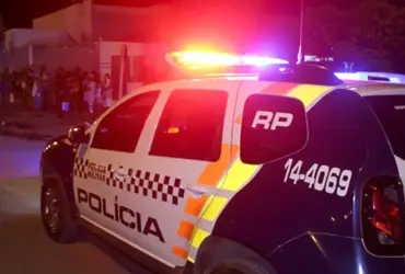 Viatura da polícia militar trafegando em via pública em direção à grupo de pessoas