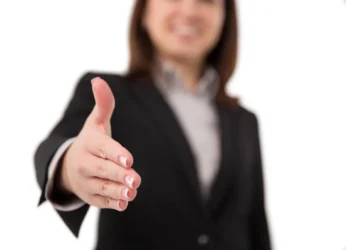 Profissional comemorando conquista no ambiente de trabalho com luz solar ao fundo