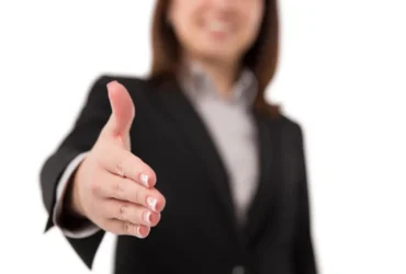 Profissional comemorando conquista no ambiente de trabalho com luz solar ao fundo