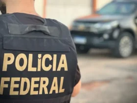 Policial federal próximo à viatura