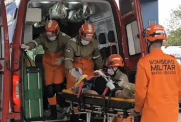 Bombeiros colocando pessoa ferida dentro da ambulância
