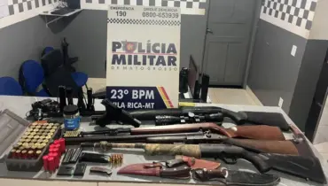 Armas apreendidas em cima de mesa