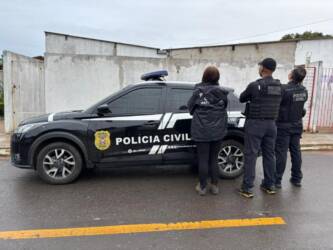 Foto de policiais civis em frente à viatura