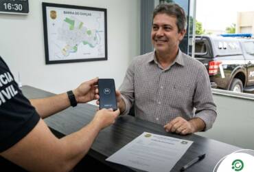 Policial Civil entregando celular Motorola para cidadão
