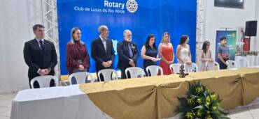 O Rotary Club de Lucas do Rio Verde realizou, na noite de quarta-feira (8), a cerimônia de transmissão de cargos da diretoria para a gestão 2026/2027. O evento reuniu associados, autoridades e convidados em uma noite de celebração ao voluntariado, com homenagens, música ao vivo e jantar de confraternização. A presidência do clube foi transmitida de Mônica Albieri para Ana Maria Bonfarini, que assume a missão de dar continuidade aos projetos desenvolvidos pela entidade no município. Durante a solenidade, o prefeito Miguel Vaz e o vereador Márcio Albieri, também integrante do Rotary Club, receberam o título Paul Harris, a maior honraria concedida pelo Rotary Internacional a pessoas que se destacam pelo apoio às ações e aos princípios da instituição. Legado de trabalho Ao encerrar dois anos à frente do clube, Mônica Albieri falou sobre o sentimento de gratidão e a responsabilidade de conduzir uma entidade com forte atuação social. “É um prazer muito, muito grande, mas é uma responsabilidade ainda maior. Hoje o coração está explodindo de alegria, de gratidão”, afirmou. Ela destacou que a gestão foi marcada por muito trabalho e pela consolidação de projetos de impacto social, como o Banco Ortopédico e o Eco Rotary, iniciativa voltada à destinação correta do lixo eletrônico. “Foi um período de muito trabalho, mas agora coroando com excelência. Não é o trabalho da Mônica Albieri, é de todo o Rotary Club de Lucas do Rio Verde”, disse. Mônica também ressaltou a importância da diretoria e dos companheiros de clube no desenvolvimento das ações. “Sem a minha diretoria eu não tenho nem palavras para pontuar o quanto eles foram importantes. Foram leais, não me abandonaram em nenhum momento”, declarou. Sobre a transição de comando, ela reforçou que o Rotary mantém a continuidade entre as gestões. “O Rotary é uma engrenagem, onde não há ruptura de uma gestão para outra. Da mesma forma que a Ana esteve ao meu lado me ajudando, eu estarei ao lado dela também em todos os momentos”, afirmou. Continuidade dos projetos Em seu primeiro discurso como presidente, Ana Maria Bonfarini disse assumir o cargo com entusiasmo e senso de responsabilidade. “É muito gratificante poder ser escolhida. É uma responsabilidade muito grande, mas vamos pra frente, porque juntos somos mais fortes”, afirmou. Integrante do Rotary há dez anos, Ana destacou que o principal compromisso da nova diretoria será dar sequência aos projetos já consolidados, especialmente o Eco Rotary. “O nosso foco principal é o lixo eletrônico, que é um projeto maravilhoso e ajuda a comunidade e o meio ambiente também”, disse. A nova presidente também ressaltou o espírito de companheirismo que marca a instituição. “O bacana é poder contar com os companheiros, que sempre estão se dedicando. O Rotary é isso: companheirismo. Na verdade, é dar de si sem pensar em si, esse é o nosso lema”, afirmou. Ana reforçou ainda que o trabalho voluntário realizado pelo clube beneficia diretamente a comunidade. “Muita gente às vezes nem sabe o que é o Rotary, porque o nosso trabalho é voluntário. Nós trabalhamos para a nossa comunidade, e isso faz um bem para todos”, destacou. Reconhecimento ao trabalho voluntário Presente na cerimônia, o prefeito Miguel Vaz destacou a importância do Rotary Club como parceiro da administração pública na execução de projetos voltados ao bem-estar da população. “O Rotary é um clube de serviço, um clube que serve. Eu particularmente tive a oportunidade de ser rotariano por alguns anos”, lembrou. Ele ressaltou que a entidade atua como um braço importante da sociedade em ações de interesse coletivo. “Quando ele atua na sociedade, ele serve de alguma forma. Tem o banco ortopédico, que é uma excelente referência aqui, e o projeto do lixo eletrônico e da reciclagem, que estamos fazendo em parceria entre o poder público e o Rotary Club”, afirmou. Miguel Vaz também destacou outras iniciativas desenvolvidas pelo clube nas áreas de saúde e assistência comunitária. “São vários serviços que o Rotary Club presta à sociedade. Por esse motivo estou aqui para prestigiar essa troca de mandato e parabenizar a presidente que está entrando e a que está saindo também”, disse. O prefeito ainda fez questão de elogiar a atuação feminina na condução da entidade. “São as mulheres que estão à frente. Então parabéns às mulheres comandando o Rotary Club e servindo a sociedade de Lucas do Rio Verde”, completou. Além da posse da nova diretoria, a noite teve um significado especial para Ana Maria Bonfarini, que comemorou aniversário na mesma data em que assumiu oficialmente a presidência do Rotary Club de Lucas do Rio Verde.
