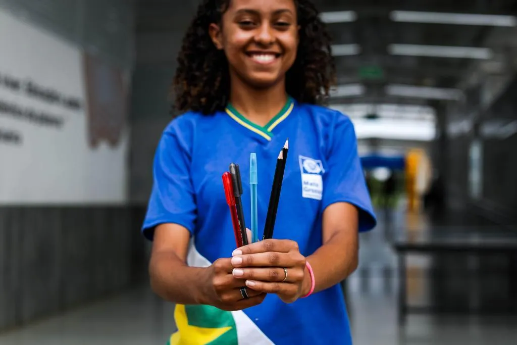 Estudante segurando canetas