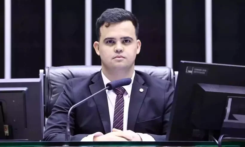 Junio amaral de terno sentado na camara dos deputados olhando para foto_1_69100.jpg